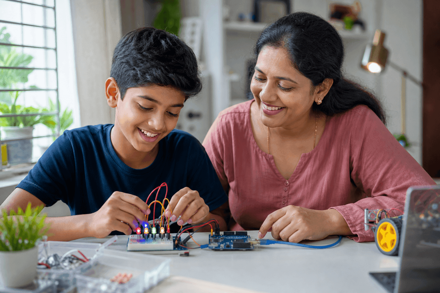 A child building an Arduino project at home with a proud parent watching